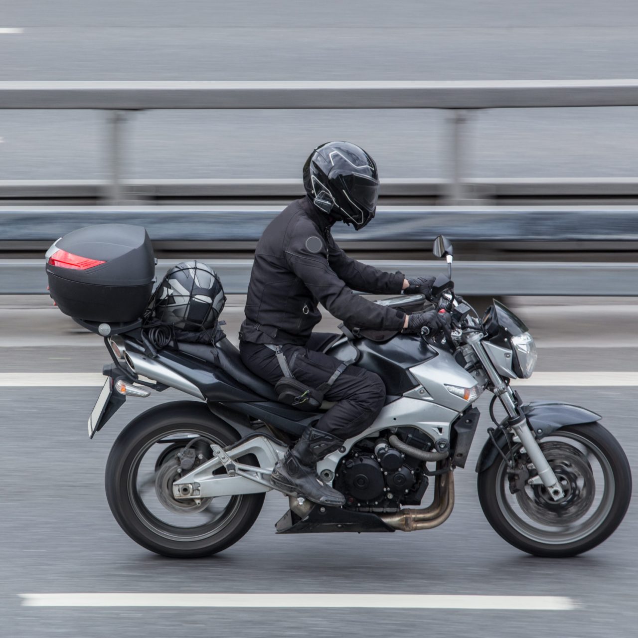 Motorcyclist in a helmet rides a motorcycle on the road. Motion blur.